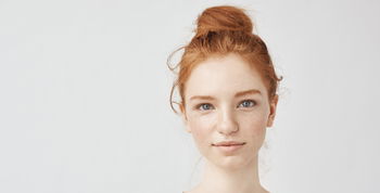 Das Bild zeigt das Gesicht einer jungen rothaarigen Frau